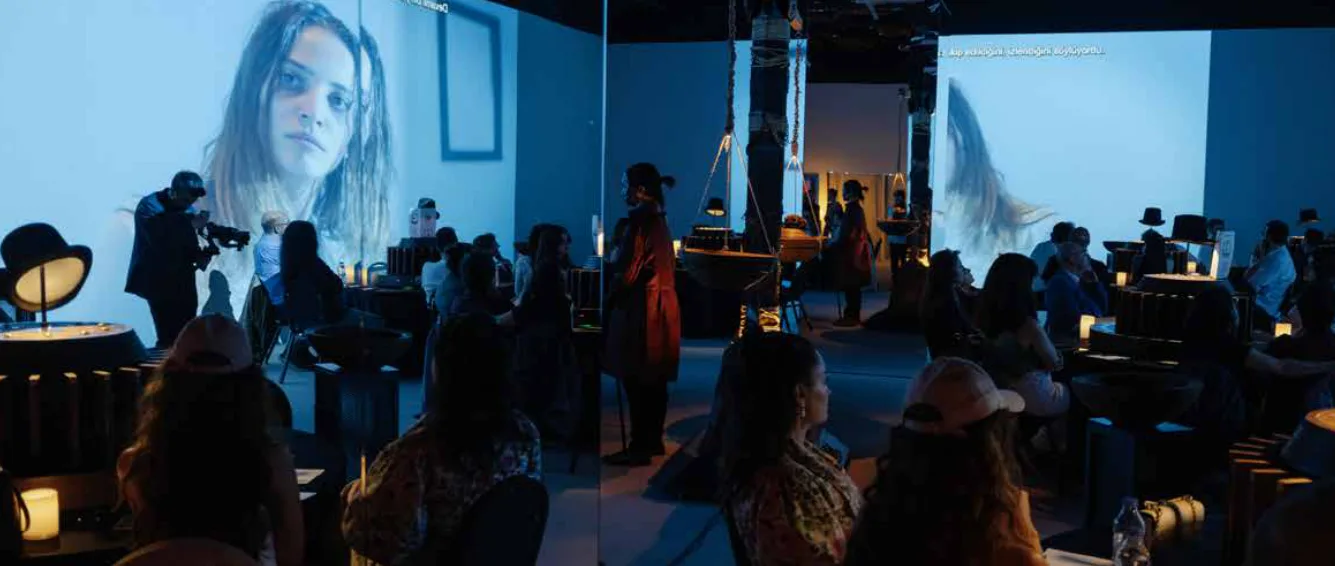 Guests seated at round tables as the projected film fills the walls of the Foreshadow hall, from a Foreshadow session